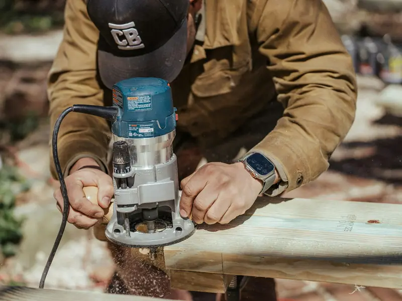 Craftsman finishing deck boards with a power tool