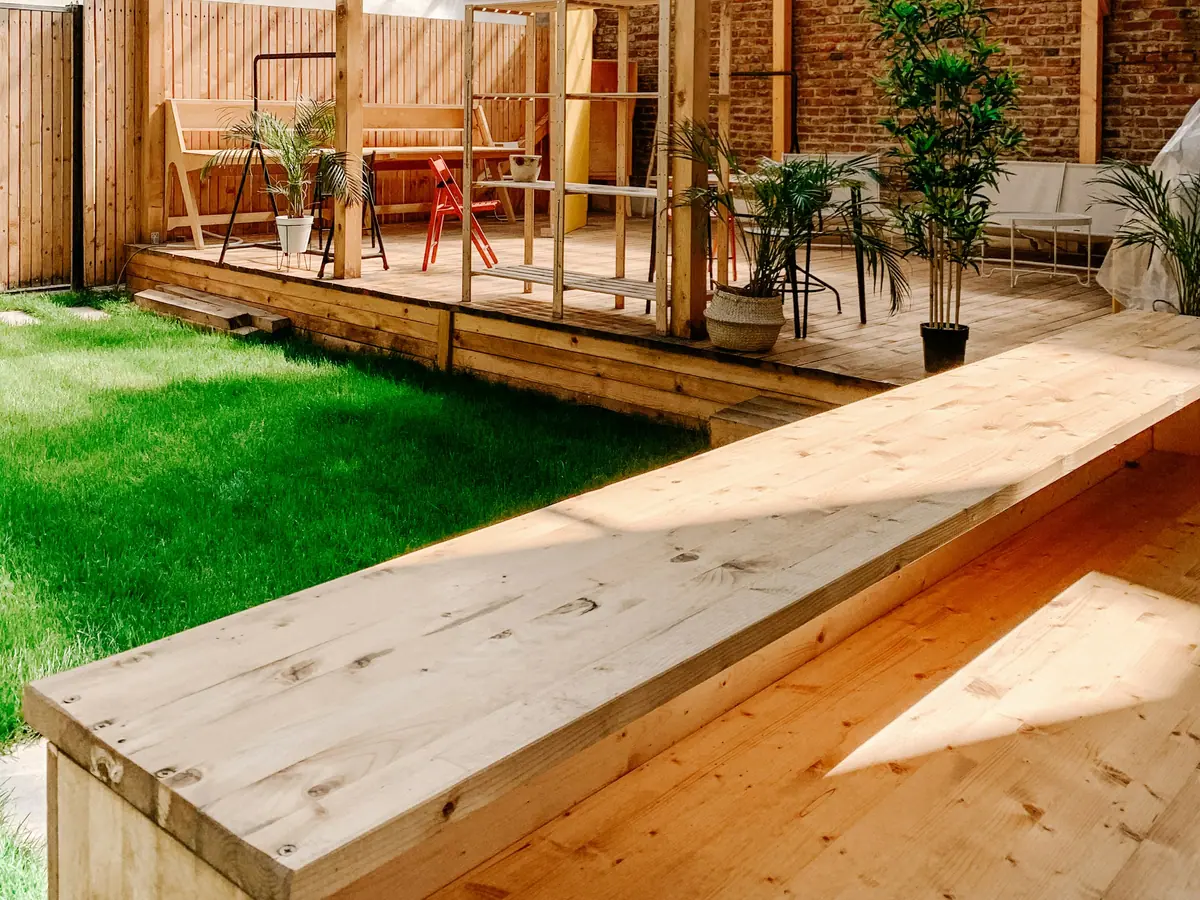 Timber pergola covering a raised wood deck with outdoor furniture