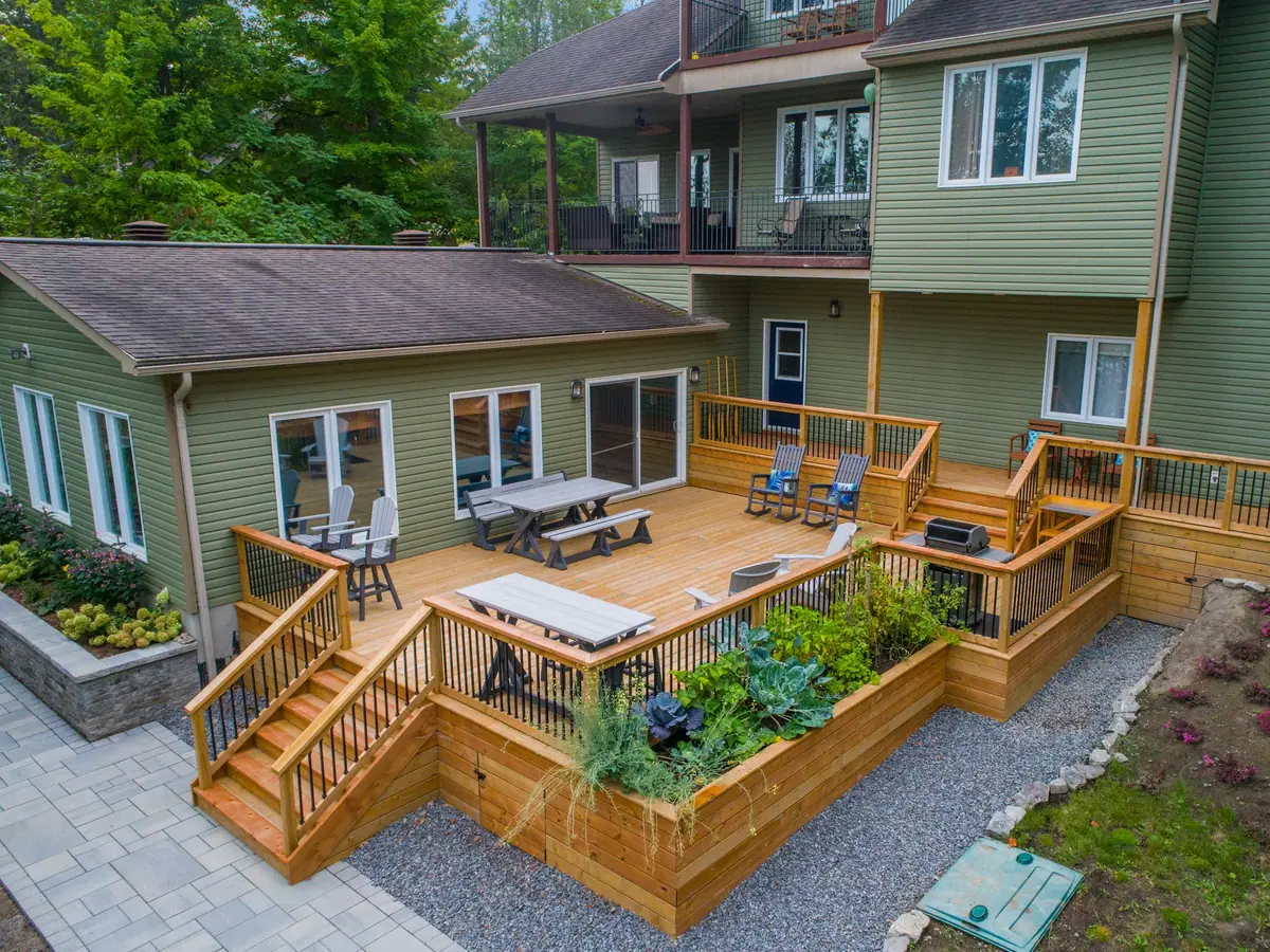 Two-level cedar deck with stairs and planters behind a house